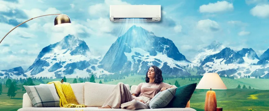 Wall-mounted mini-split head above a living room with a mountain view through the window