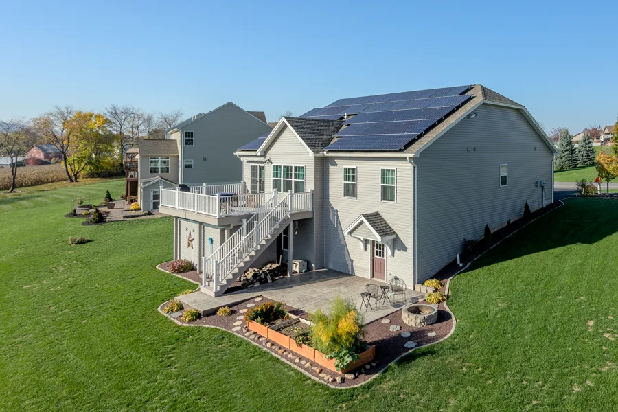 Two-storey Bellefonte home with a raised deck and a rooftop solar array