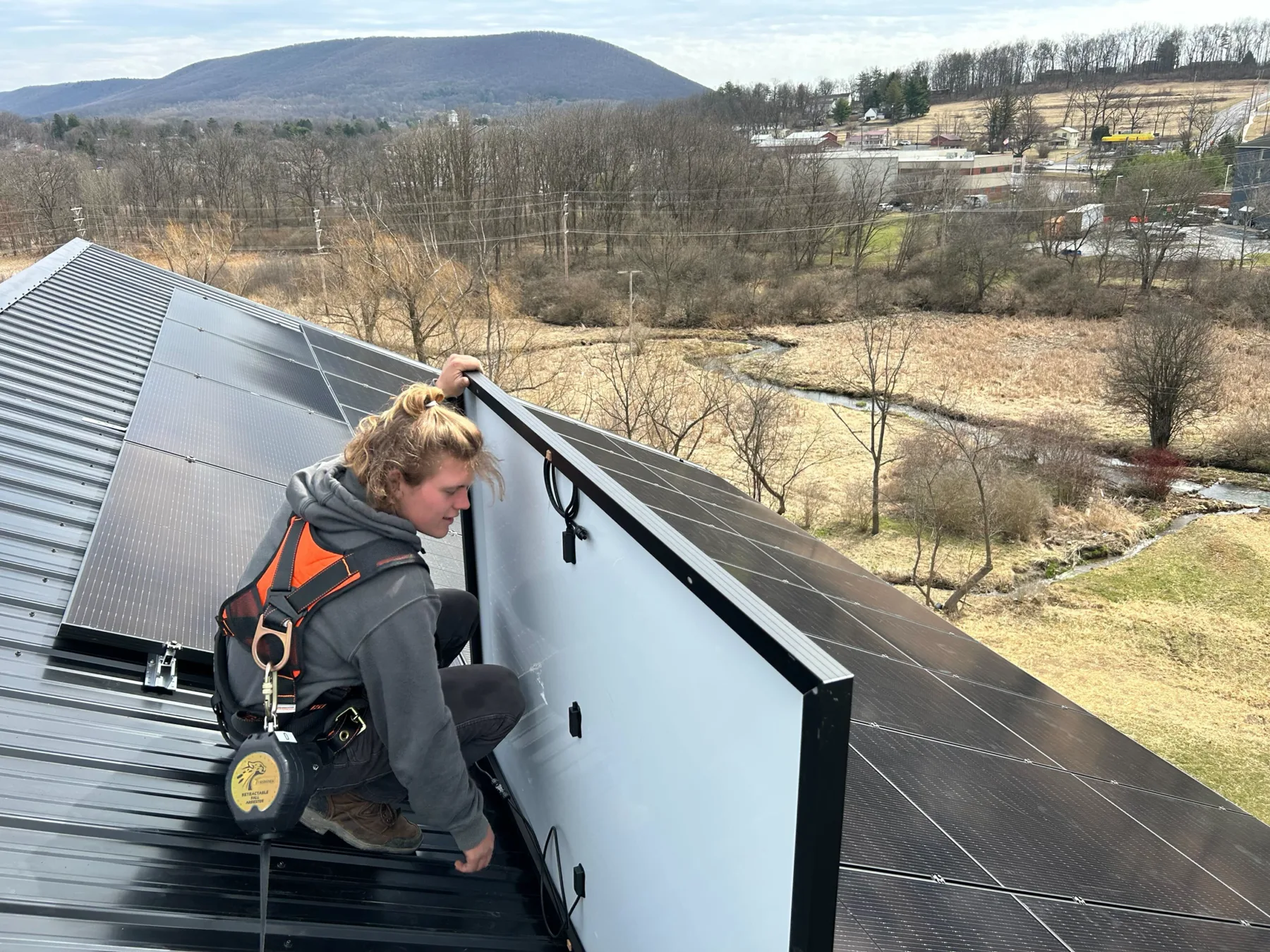Sun Directed installer setting a solar module on a roof