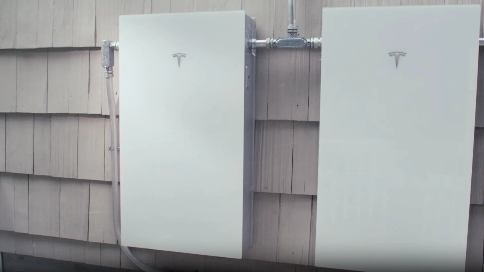 Tesla Powerwall 3 mounted on the outside of a clapboard house